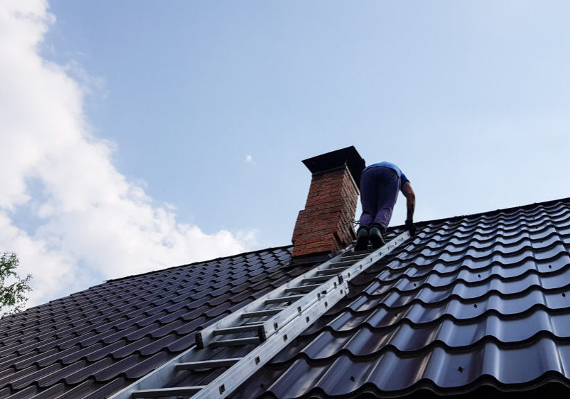 A,Man,Climbs,A,Metal,Ladder,To,The,Roof,Of